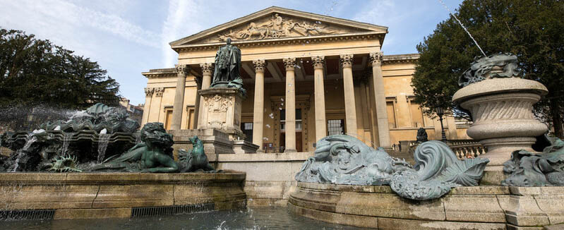 The victoria rooms, an old building with classical columns and statues in front of it.
